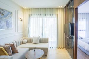 a living room with a white couch and a bed at Résidence Palm - Palmiers in Casablanca