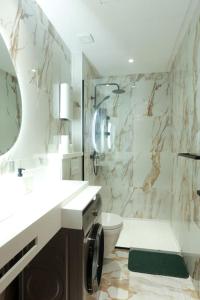 a bathroom with a sink and a toilet and a mirror at Résidence Palm - Palmiers in Casablanca