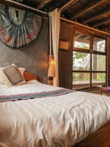 a bedroom with a white bed with a window at Luckydaisy Buffalo House in Sapa