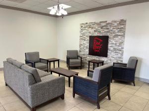 a waiting room with chairs and a couch and tables at Red Roof Inn Dunn in Dunn