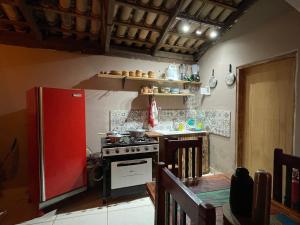 a kitchen with a stove and a red refrigerator at Casas Goiás - Suítes Beira Rio - Centro Histórico in Goiás