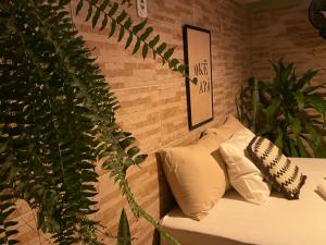 um quarto com um sofá com almofadas e uma planta em Casas Goiás - Suítes Beira Rio - Centro Histórico em Goiás