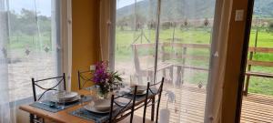 a dining room with a table and chairs and a large window at Refugio Pucalan Lodge in Puchuncaví