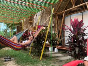 a woman laying in a hammock under a tent at Cabaña Beach Palomino in Palomino