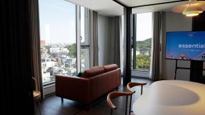 Habitación de hotel con silla y ventana grande en Wecostay Namsan, en Seúl