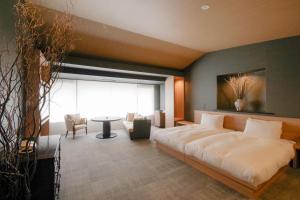 a bedroom with a large bed and a table at Tokiwa Hotel in Kofu