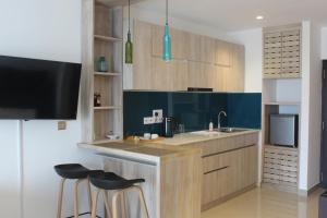 a kitchen with a sink and a counter with stools at Luxury Ocean Condos by Travel Bee in Negombo