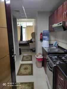 uma cozinha com fogão e uma cozinha com tapetes em El massa Quit apartment em Sharjah