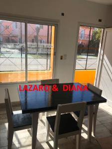 a black table and chairs in a room with windows at Lázaro & Diana in San Clemente del Tuyú