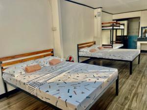 Zwei Betten befinden sich in einem Zimmer mit einer gedankenlosen, gedankenlosen, gedankenlosen, gedankenlosen, leidenschaftlichen in der Unterkunft Maria Kulafu Studio Deluxe in Masbate