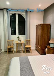 um quarto com uma cama, 2 cadeiras e uma mesa em Homestay Song Ngọc Phan Thiết em Phan Thiet