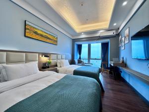 Habitación de hotel con 2 camas y TV en Guangzhou Xing Yi International Apartment Hotel - Vertical City Branch, en Guangzhou