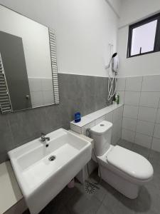 サンダカンにあるHappy Houseの洗面台、トイレ、鏡のあるバスルーム