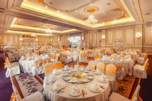a large banquet hall with white tables and yellow chairs at Dalat Palace Heritage Hotel in Da Lat