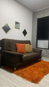 sala de estar con sofá negro y alfombra naranja en BORA, Apto 301 Tu Espacio Fuera de Casa, en Ibagué