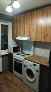 a kitchen with a stove and a washing machine at трёхкомнатная после ремонта с удобным расположением in Karagandy