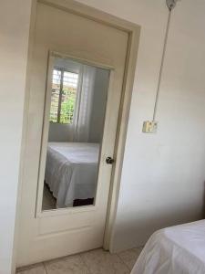 a bedroom with a mirror and a bed in a room at Alojamiento Samanà in Santa Bárbara de Samaná