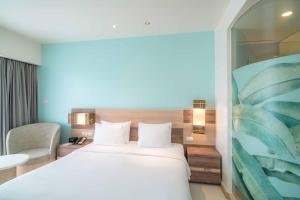 um quarto de hotel com uma cama e uma cadeira em Holiday Inn Express Phuket Patong Beach Central, an IHG Hotel em Praia de Patong