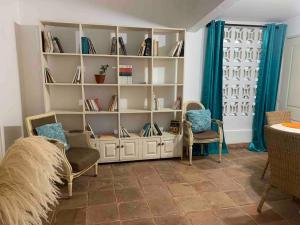 a book shelf with two chairs and a cat sitting in it at Alojamiento Samanà in Santa Bárbara de Samaná