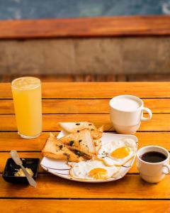 a plate of eggs and toast and a glass of orange juice at Room in Guest room - Hb8 Quadruple Room with shared bathroom in Cartagena de Indias