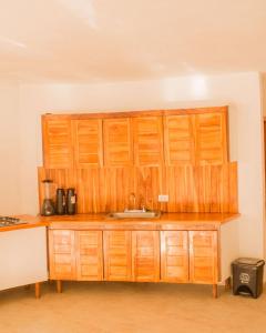 a kitchen with a sink and wooden cabinets at Room in Guest room - Hb8 Quadruple Room with shared bathroom in Cartagena de Indias