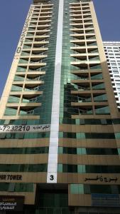 um edifício alto com o número nele em El massa Quit apartment em Sharjah