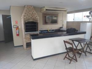 cocina con chimenea, mesa y sillas en Apartamento 2Q, 5 pessoas excelente localização en Bauru