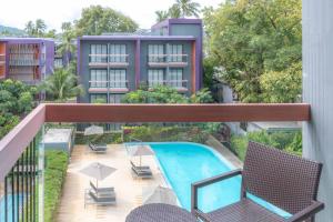 an apartment balcony with a swimming pool and chairs at Holiday Inn Express Phuket Patong Beach Central, an IHG Hotel in Patong Beach