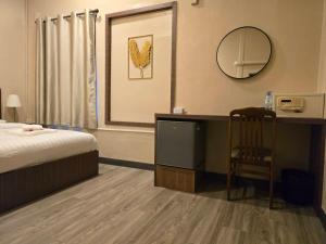 a bedroom with a bed and a desk and a mirror at Victory place 2 (Golden Mount) in Bangkok