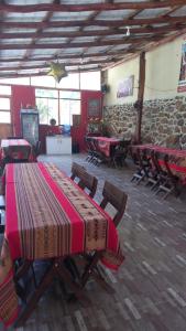 a room with a table and chairs and a stone wall at Secret Valley House Cusco in Ollantaytambo