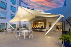 - une tente blanche sur une terrasse avec des tables et des chaises dans l'établissement Four Points by Sheraton Caguas Real, à Caguas