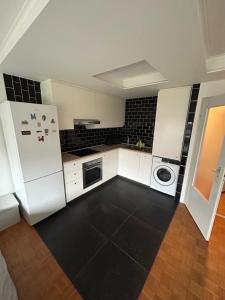 una cucina con elettrodomestici bianchi e una parete di piastrelle nere di Flat @Mechelen centrum a Mechelen