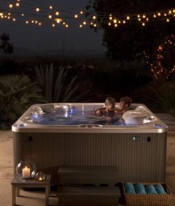 um casal de crianças a tomar banho numa banheira de hidromassagem em 10 Bedroom 5 Star Luxury Villa & Heated Pool for 5 to 30 Guests near Alicante em Mutxamel