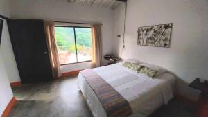 1 dormitorio con cama y ventana grande en Casa San Cayetano en Santa Marta