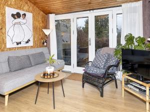 ein Wohnzimmer mit einem Sofa und einem TV in der Unterkunft Holiday home Løgstør IX in Løgstør