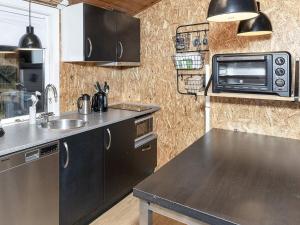 eine Küche mit einer Spüle und einer Mikrowelle in der Unterkunft Holiday home Løgstør IX in Løgstør