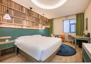 um quarto com uma grande cama branca e uma secretária em Mehood Theater Hotel, Zhonglou Metro Station Huimin Street em Xi'an