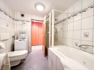 a bathroom with a tub and a toilet and a sink at FEWO Dorfglück in Oberstaufen