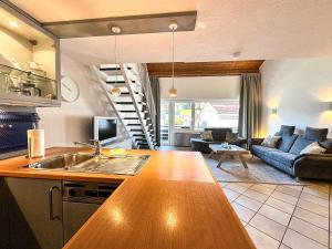 a kitchen with a sink and a living room at FEWO Dorfglück in Oberstaufen