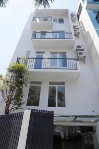 a white building with chairs and a balcony at Angie's Home in Ho Chi Minh City