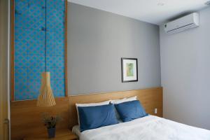 a bedroom with a large bed with blue pillows at Angie's Home in Ho Chi Minh City