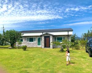 a little girl standing in front of a house at On Dang in Gyeongju
