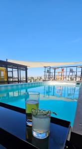 a drink on a table next to a swimming pool at ALT URBANA in León