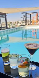 three drinks on a table next to a swimming pool at ALT URBANA in León