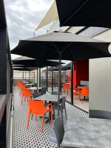 an outdoor patio with tables and chairs and umbrellas at ALT URBANA in León