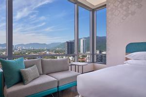 Penang Marriott Hotel في جورج تاون: غرفة نوم بسرير واريكة ونوافذ