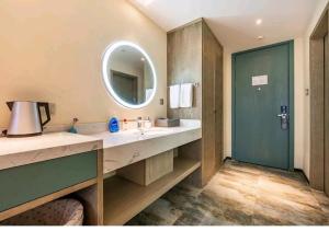 a bathroom with a large sink and a mirror at Mehood Theater Hotel, Zhonglou Metro Station Huimin Street in Xi'an +22 photos