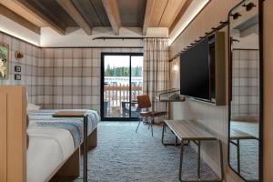 a hotel room with a bed and a flat screen tv at Moxy Banff in Banff