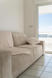 un sofá en una sala de estar con una gran ventana en Location T2 Chic ducos proche de l'aéroport en Ducos
