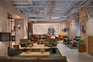 a lobby with couches and chairs in a room at MOXY NYC Times Square in New York